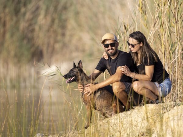 Happy couple with a dog in a lake