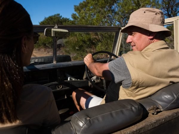 Man with woman looking away while driving off road vehicle