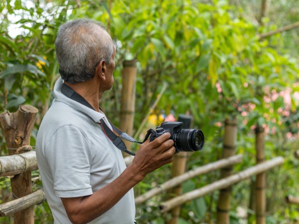 Senior nature photographer on mountain - professional photographer taking photos of nature in the forest