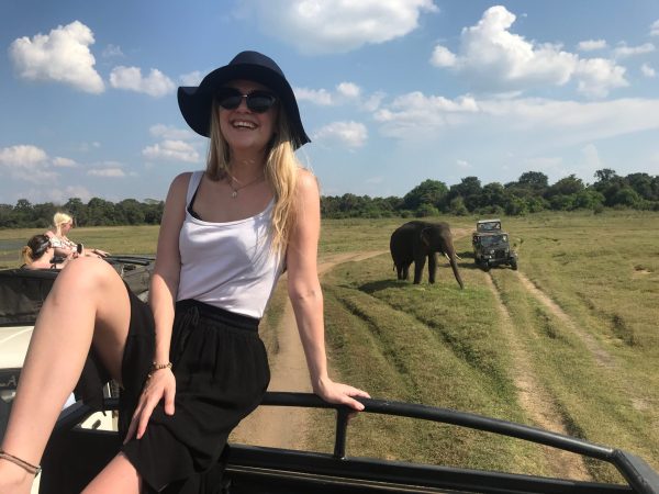 young-woman-sitting-by-elephant-vehicle-field